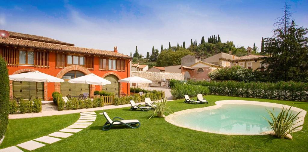 um quintal com cadeiras e uma piscina e uma casa em Villa Avesani em Pastrengo