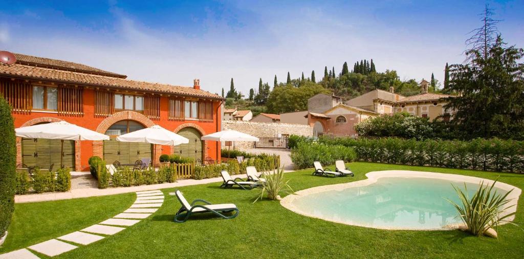 a yard with chairs and a swimming pool and a house at Villa Avesani in Pastrengo