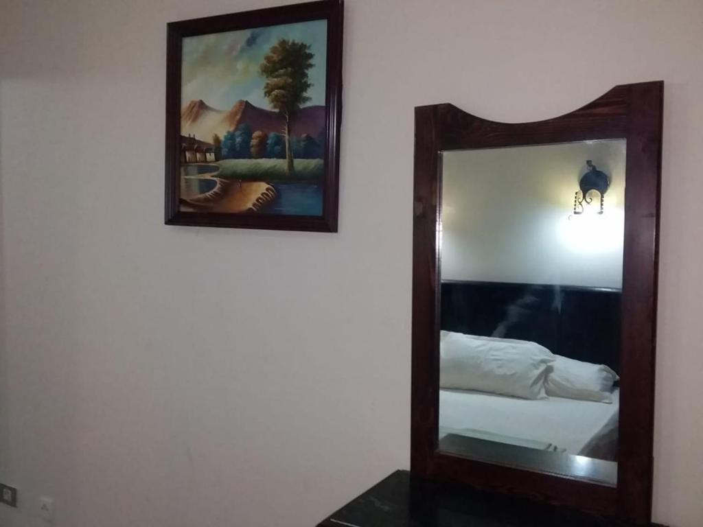 a mirror hanging on a wall next to a bed at 321or322 the finest Porto Marina Chalets Tower 3 in El Alamein