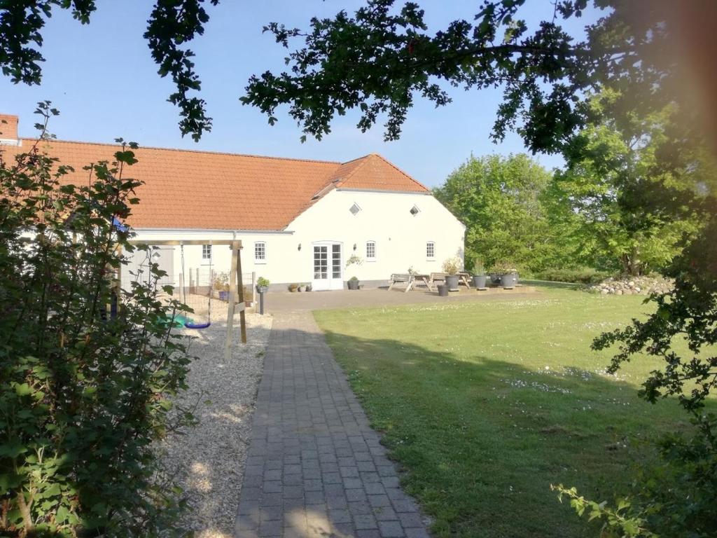 a large white building with a grass yard at Rosengaard holiday apartment and B&B in Bramming