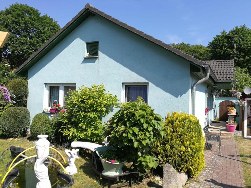 una casa azul con un banco en un patio en Fewo Seerose, en Zempin