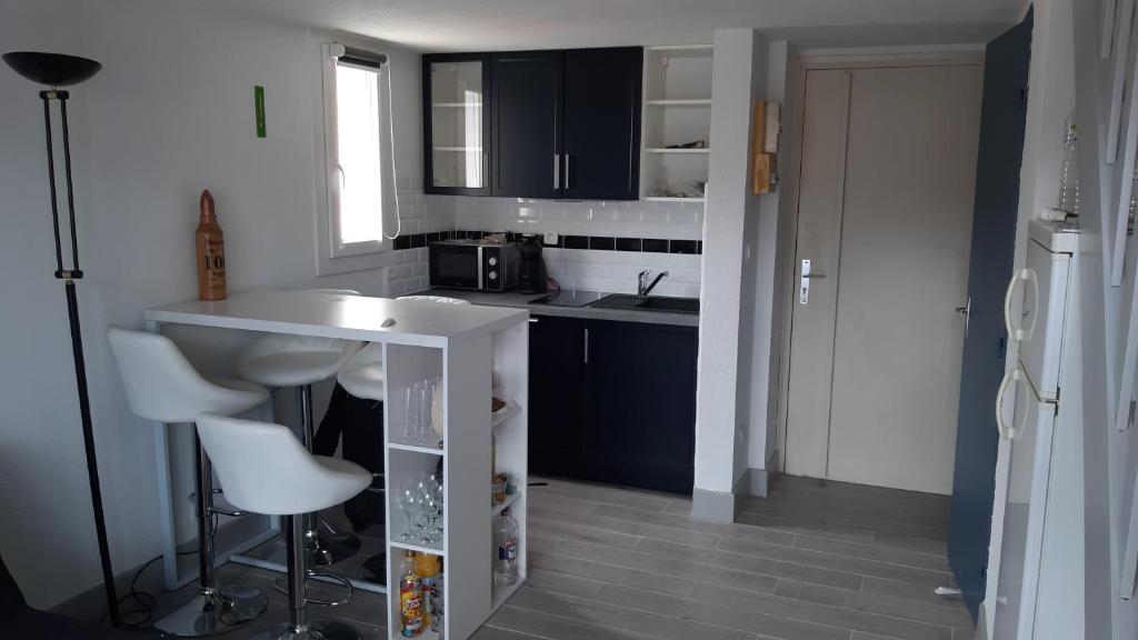 une petite cuisine avec un comptoir blanc et un évier dans l'établissement Appartement T2 