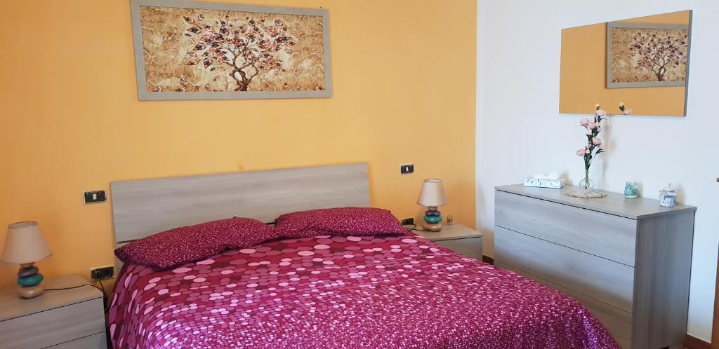 - une chambre avec un lit et une couette rose dans l'établissement Casa Lory, à Pescina