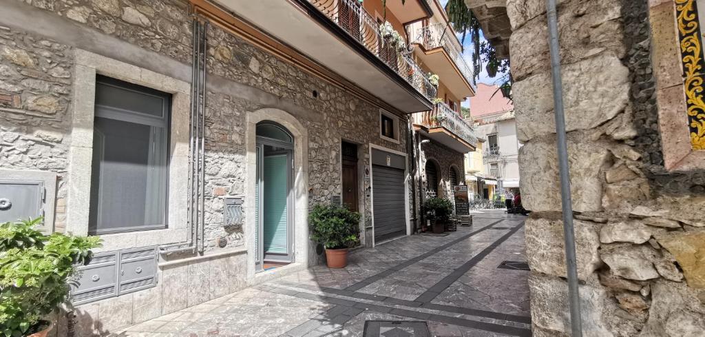 une allée vide dans un vieux bâtiment en pierre dans l'établissement luxury Apartment Carmen n 2 Centro Storico di Taormina, à Taormine