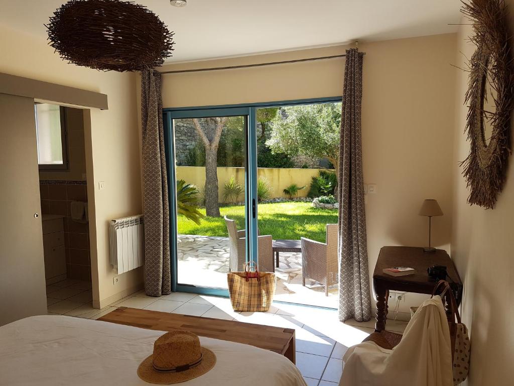 a bedroom with a sliding glass door to a patio at chambres d'hôtes du moulin in Peyriac-de-Mer