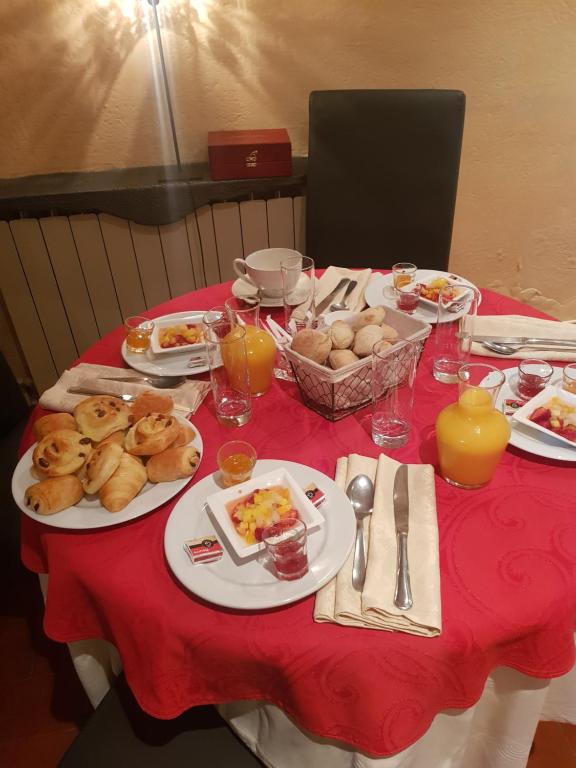 a table with plates of food on a red table cloth at Le Relais Des Dentelles in Beaumes-de-Venise