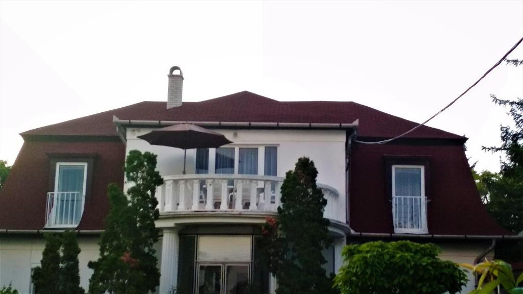 a house with a balcony with an umbrella at AnitApartman in Balatonfüred