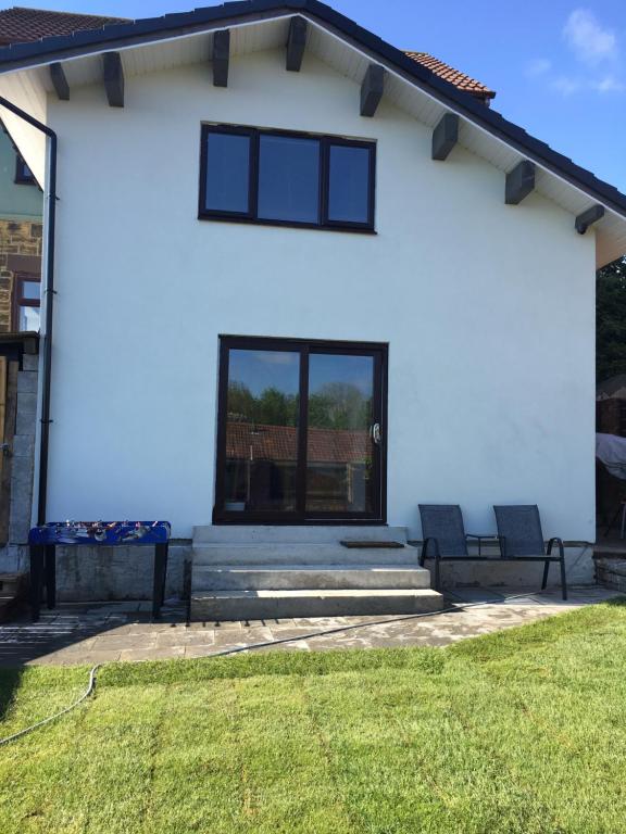 a white house with two windows and a lawn at Casa in Gateshead