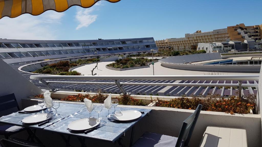- une table sur un balcon avec vue sur un bâtiment dans l'établissement Cap d'Agde Port Ambonne, au Cap d'Agde