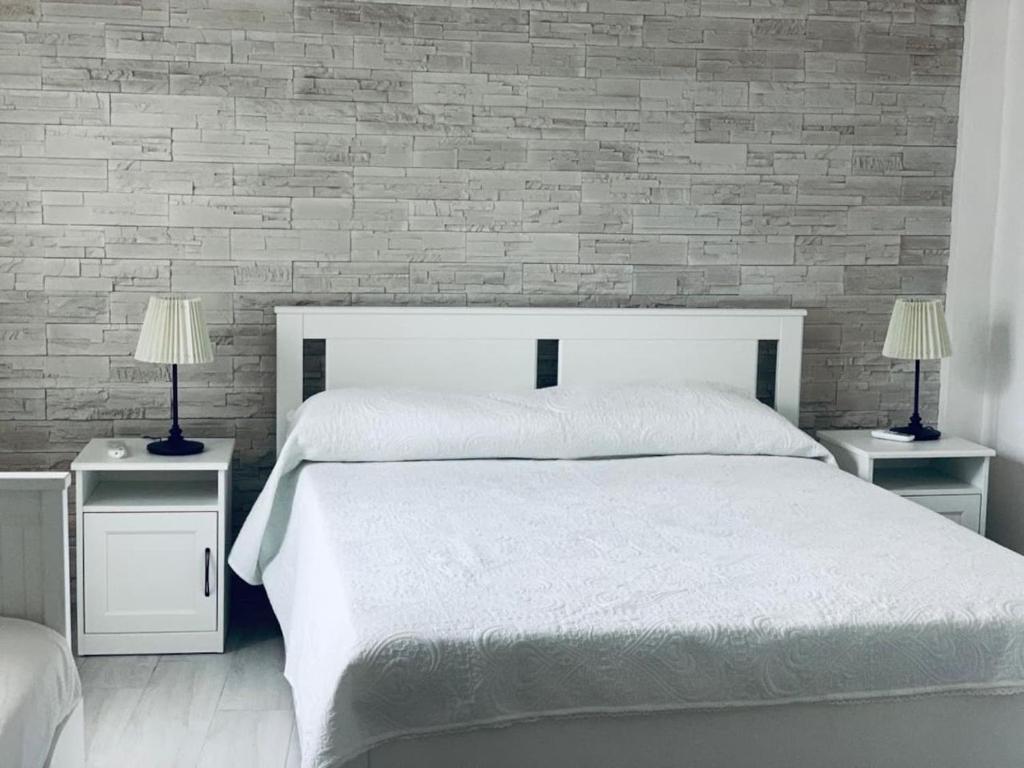 een slaapkamer met een groot wit bed en 2 nachtkastjes bij Terra del SUD in Giovinazzo