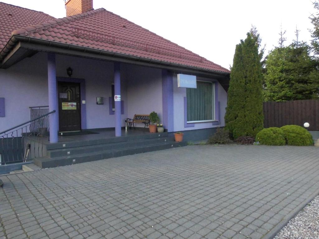 a house with a porch with a bench on it at Gościniec Suwalska in Gołdap