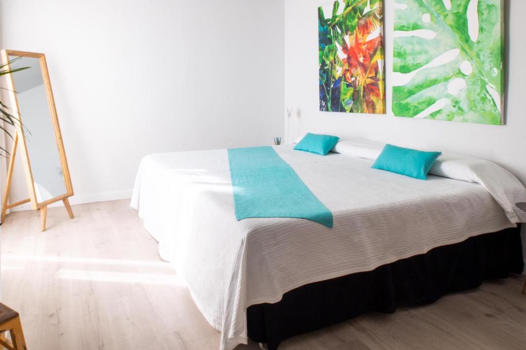 a bedroom with a bed with a painting on the wall at FORMENTERADREAMING SUITe in La Savina