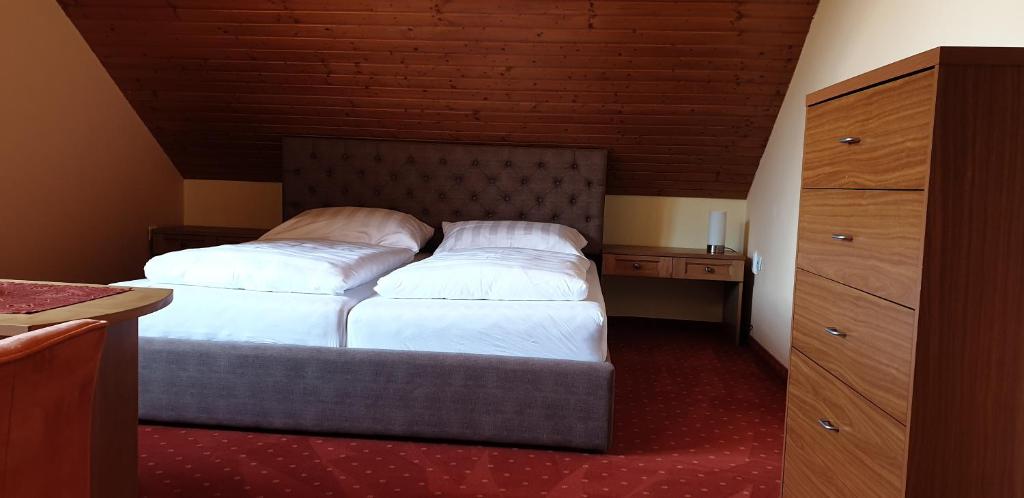 A bed or beds in a room at Penzion Montana