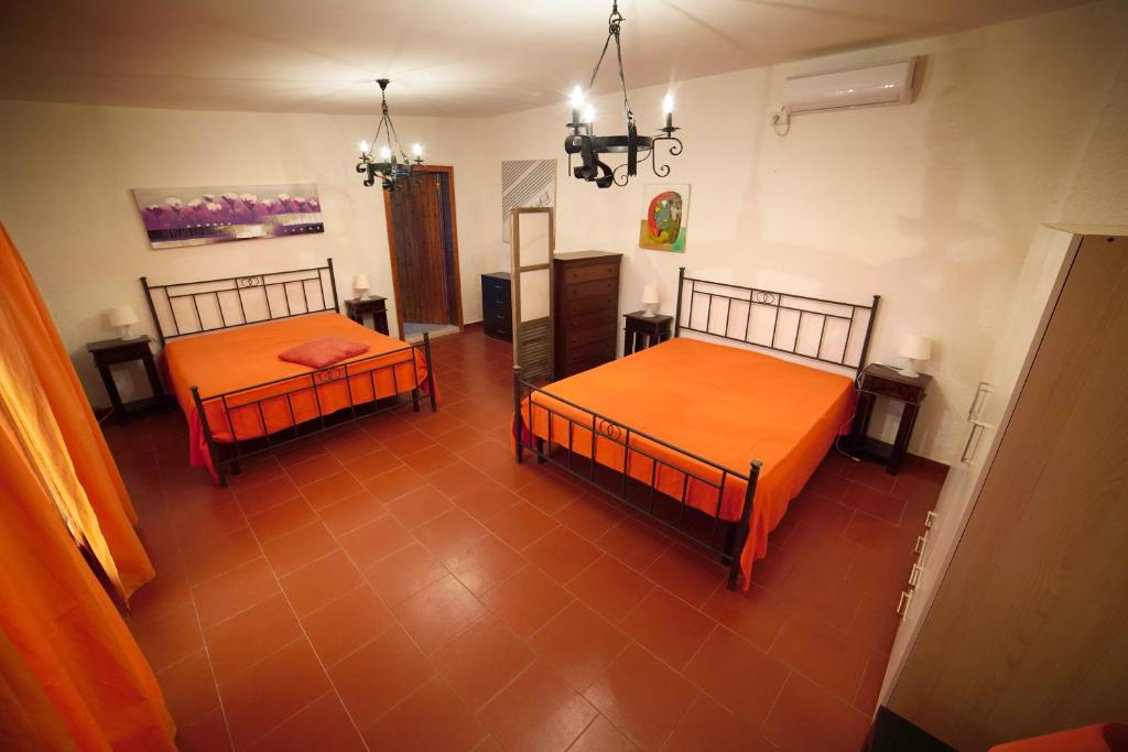 ポルト・チェザーレオにあるB&B Mary Porto Cesareoのオレンジのシーツが備わる客室内のベッド2台