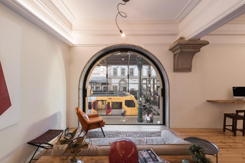 a living room with a large window and a yellow train at The Passenger Hostel in Porto