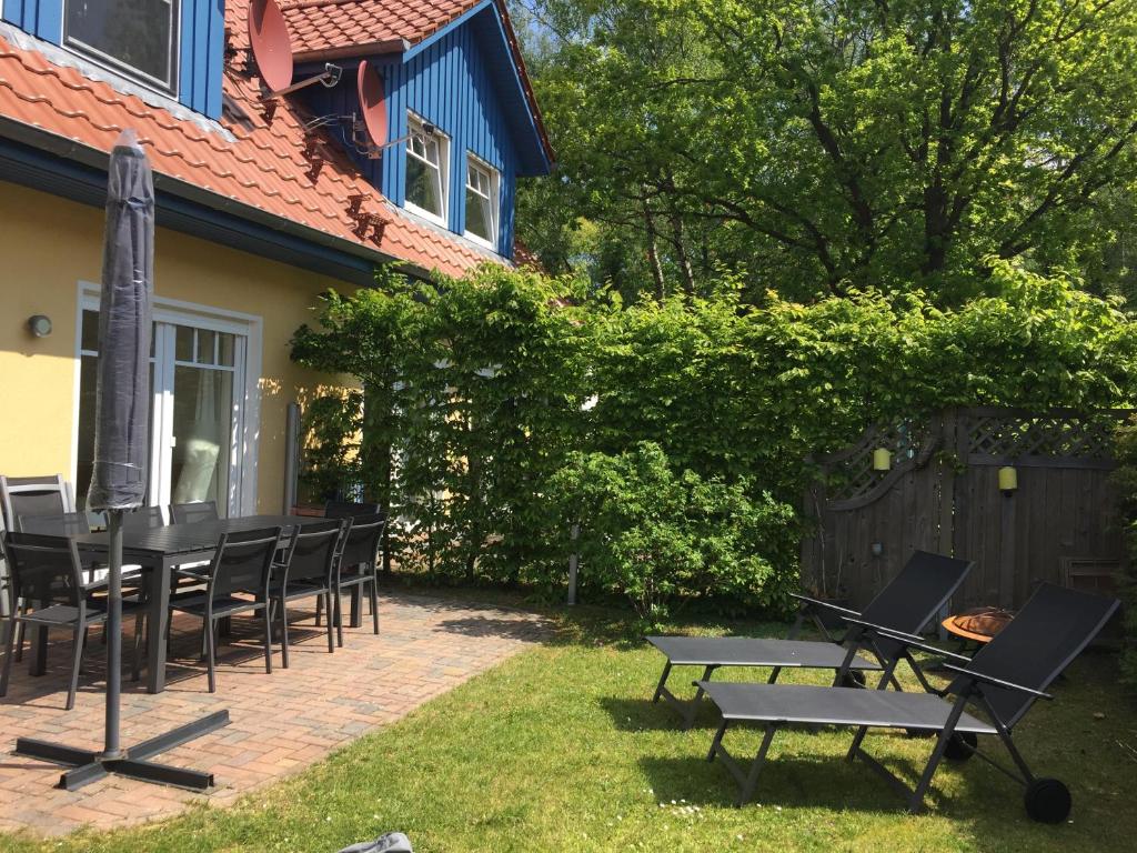 a patio with chairs and a table and a grill at Meeresbrise in Graal-Müritz