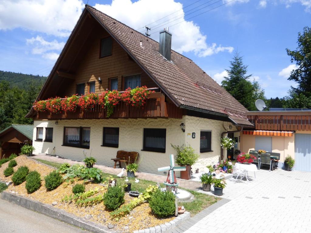 una casa con flores a un lado. en Ferienwohnung Bühler, en Alpirsbach