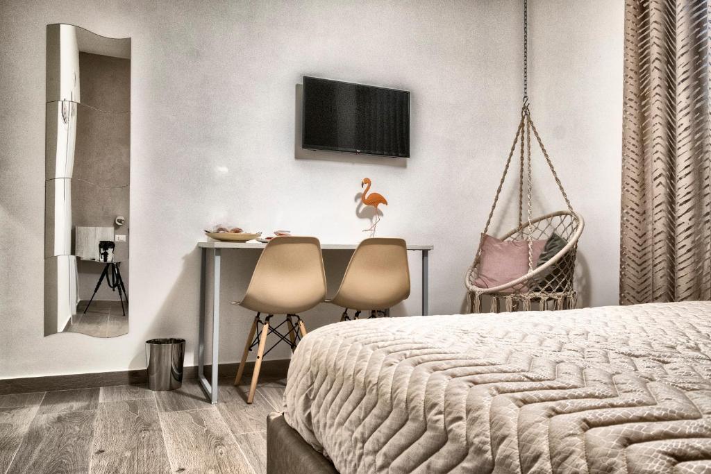 um quarto com uma cama e uma mesa com 2 cadeiras em DIMORA FLEGREA room & breakfast em Pozzuoli