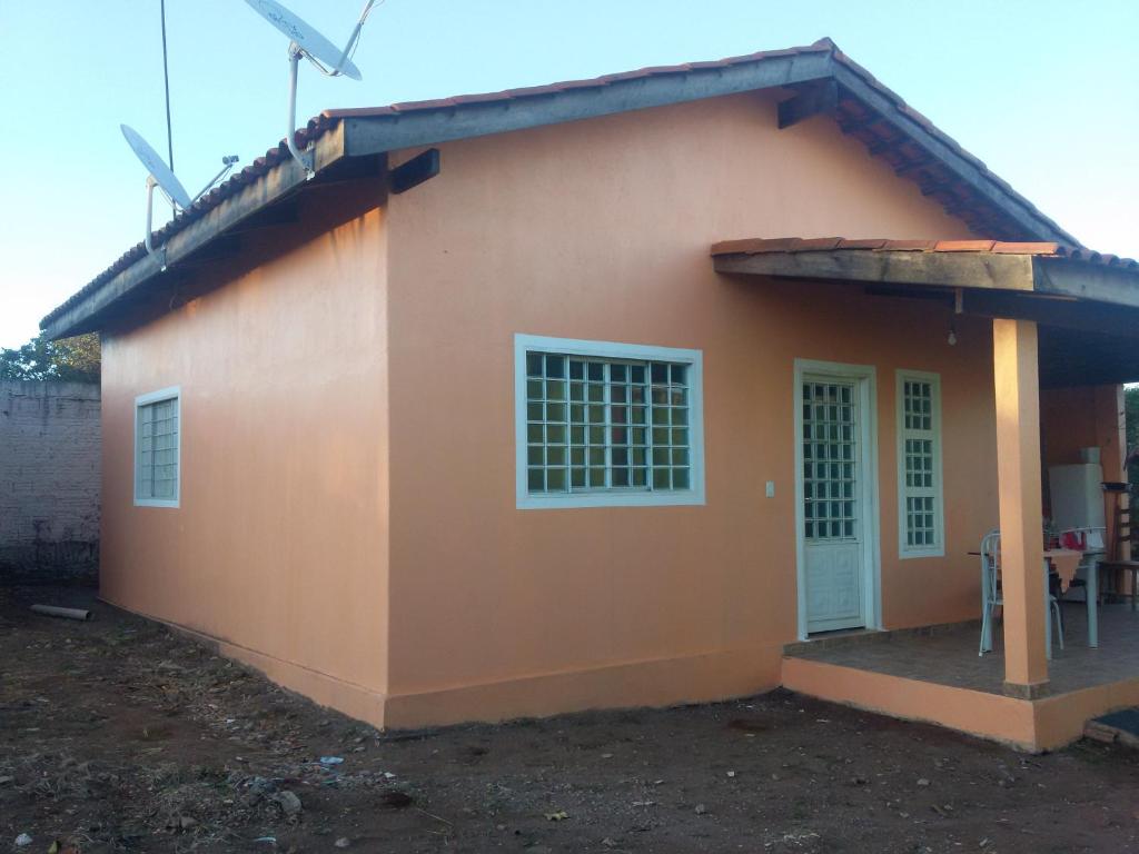 a small house with an orange wall at Casa Flor De Liz in Alto Paraíso de Goiás