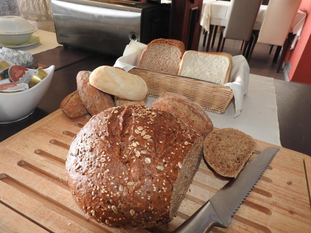 a group of bread on a cutting board with a knife at Hill View Hotel Apartments in Pissouri