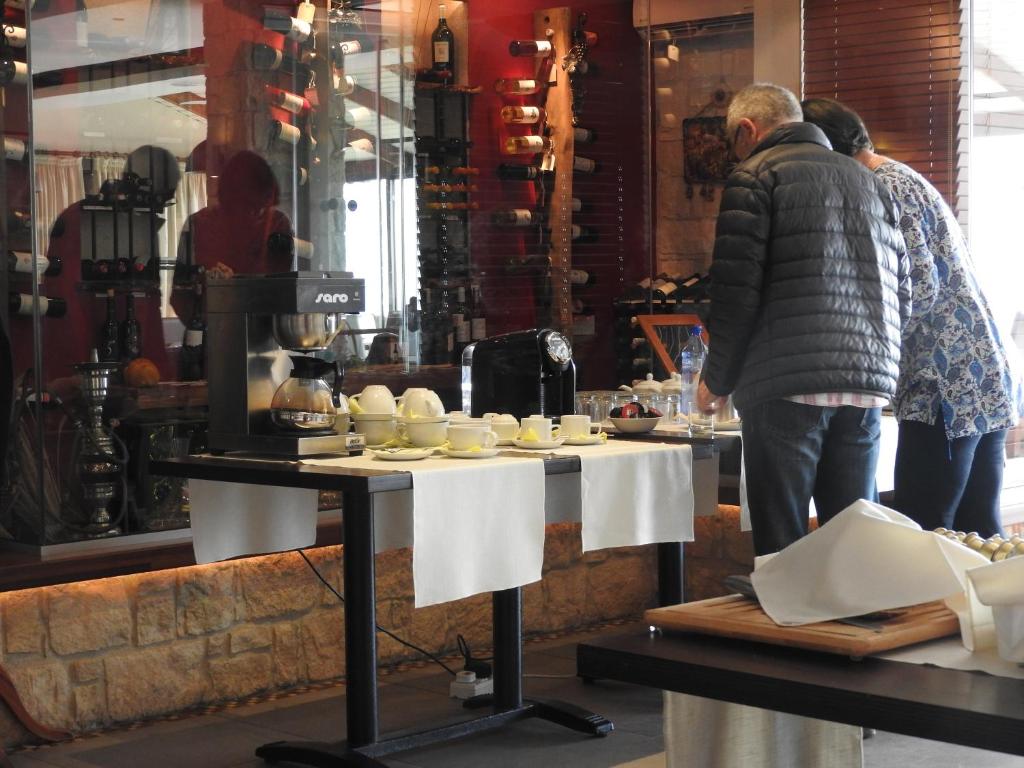 a man standing in front of a table with food at Hill View Hotel Apartments in Pissouri