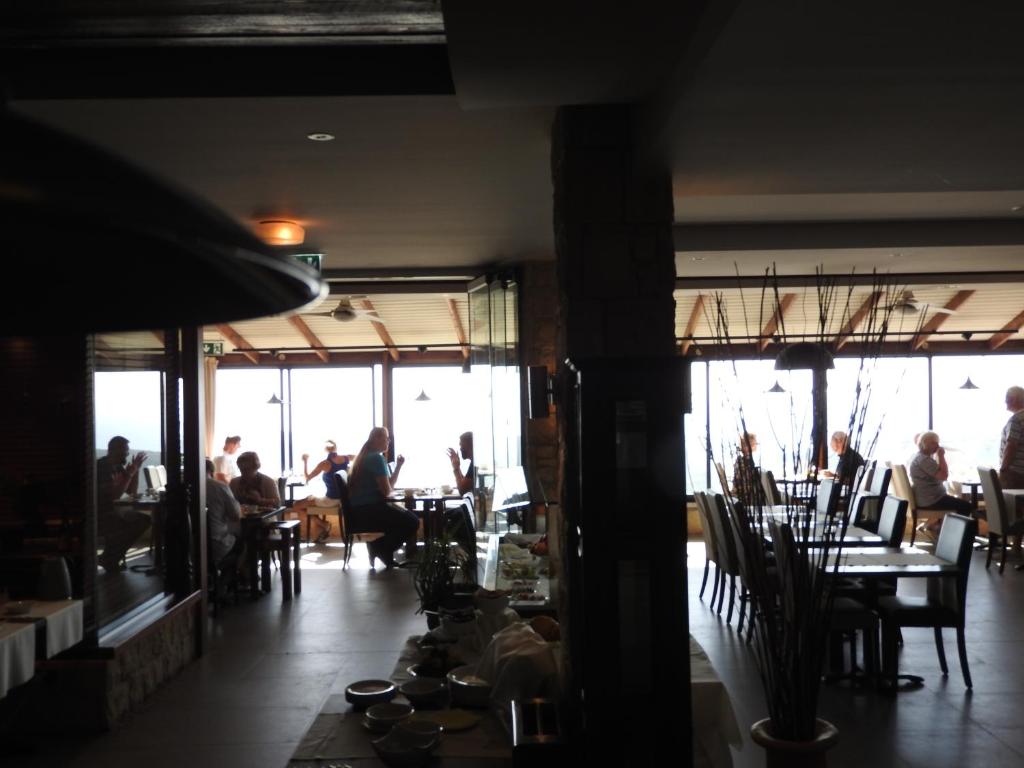 a room with people sitting at tables in a restaurant at Hill View Hotel Apartments in Pissouri