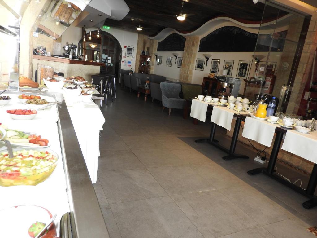 a restaurant with white tables with food on them at Hill View Hotel Apartments in Pissouri