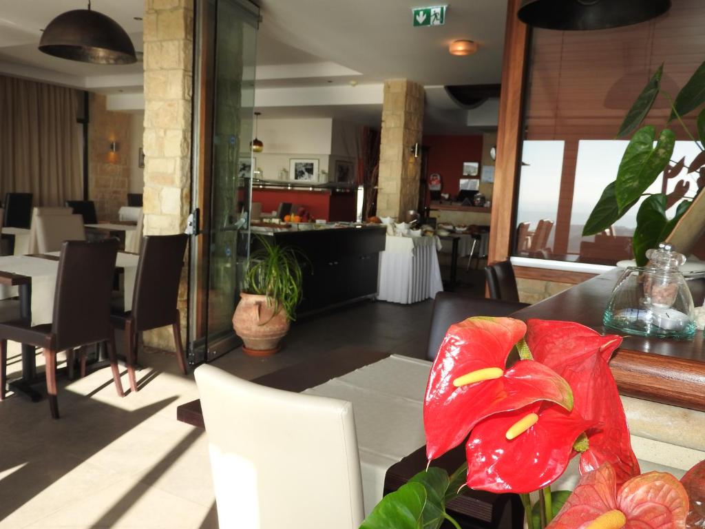 a dining room with a red flower on a table at Hill View Hotel Apartments in Pissouri
