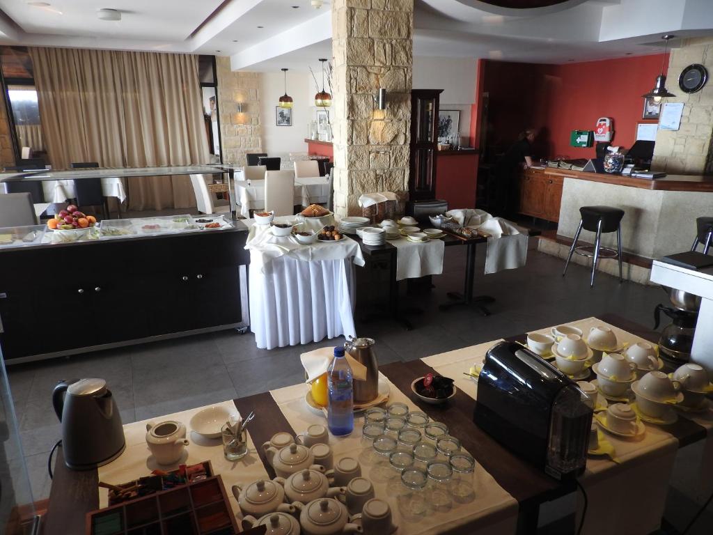 a large kitchen with tables and cups and dishes at Hill View Hotel Apartments in Pissouri