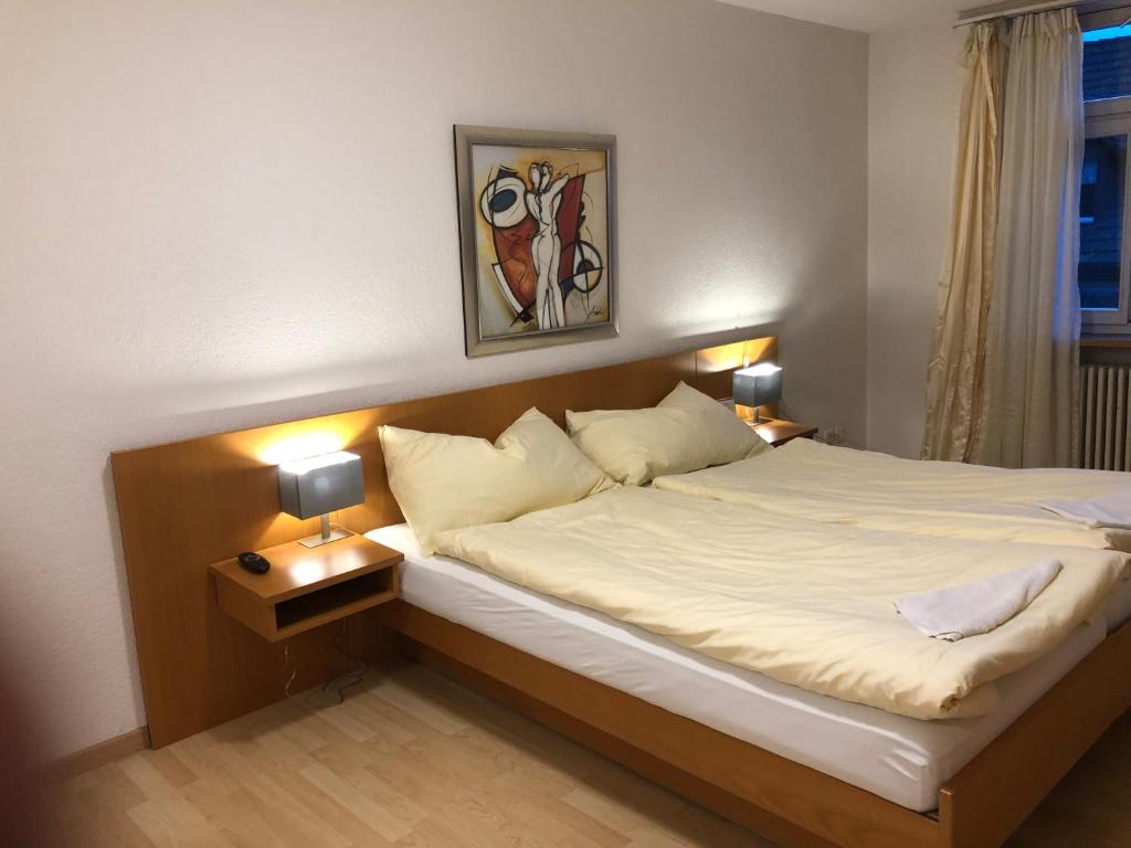 1 dormitorio con 1 cama grande y 2 lámparas en SASS APARTHOTEL, en Schönenwerd