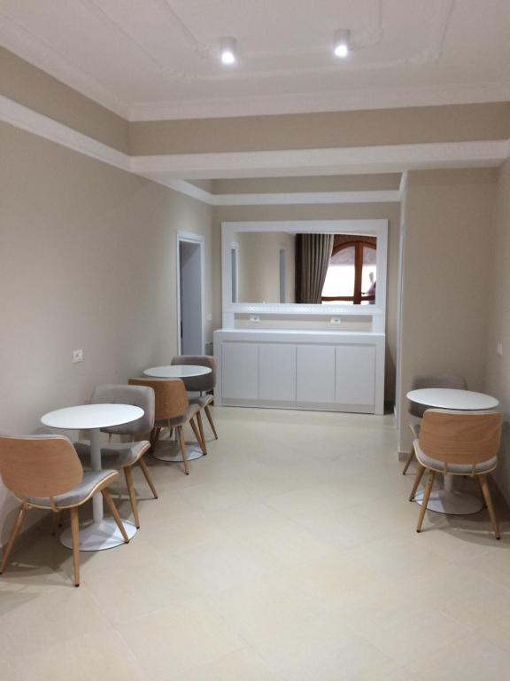 una stanza con tavoli e sedie e una finestra di MERKAJ HOTEL BERAT a Berat