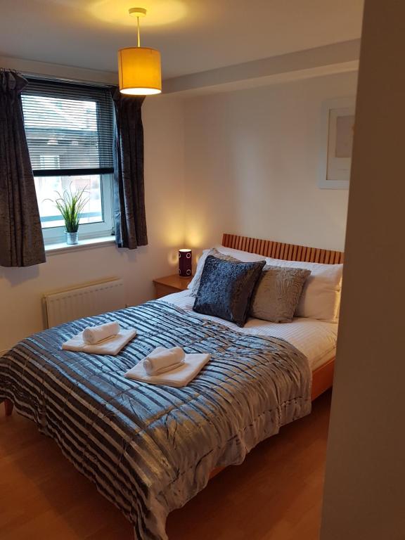 エディンバラにあるExecutive Open Plan Apartment, Leithのベッドルーム1室(ベッド1台、タオル2枚付)