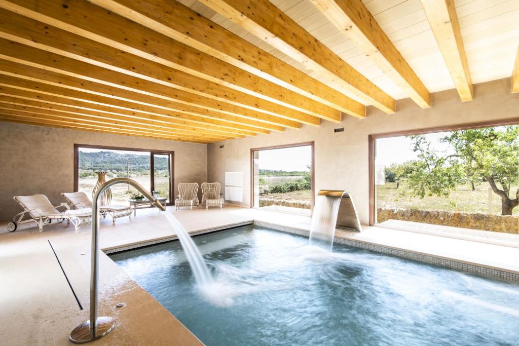 a swimming pool with a waterfall in a house at Aumallia Hotel & Spa in Felanitx