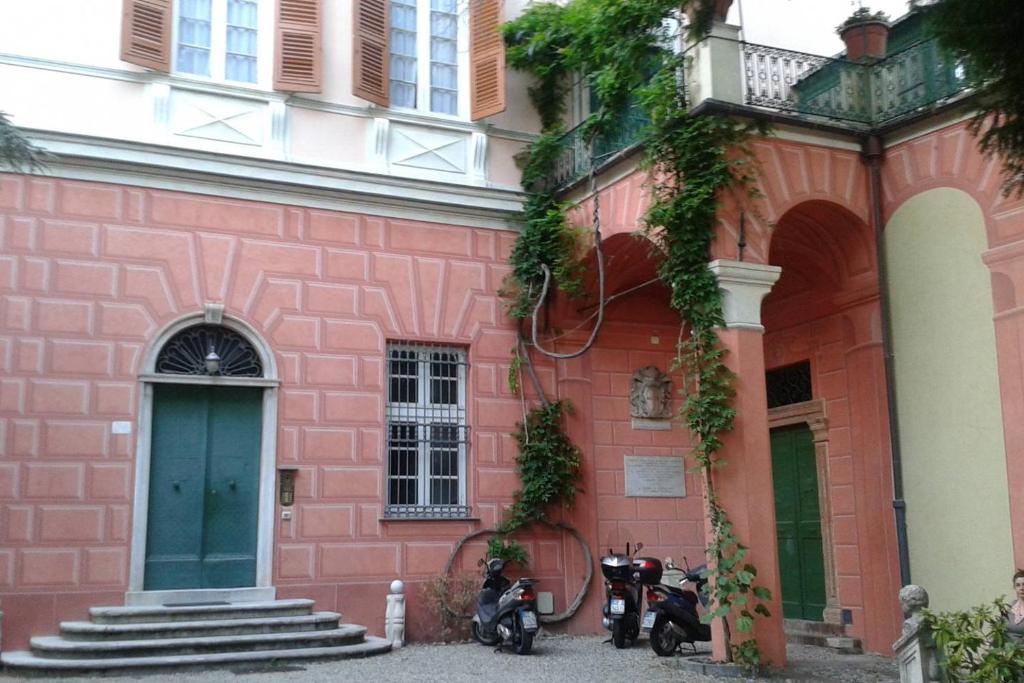 un edificio rosa con dos motocicletas estacionadas frente a él en Sweet dreams a Villa Migone, en Génova