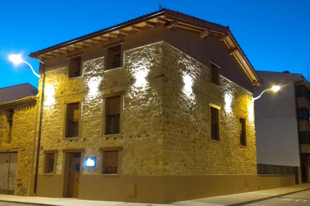 un antiguo edificio de piedra con luces. en Hostal Rural Villa de Mendavia, en Mondaria