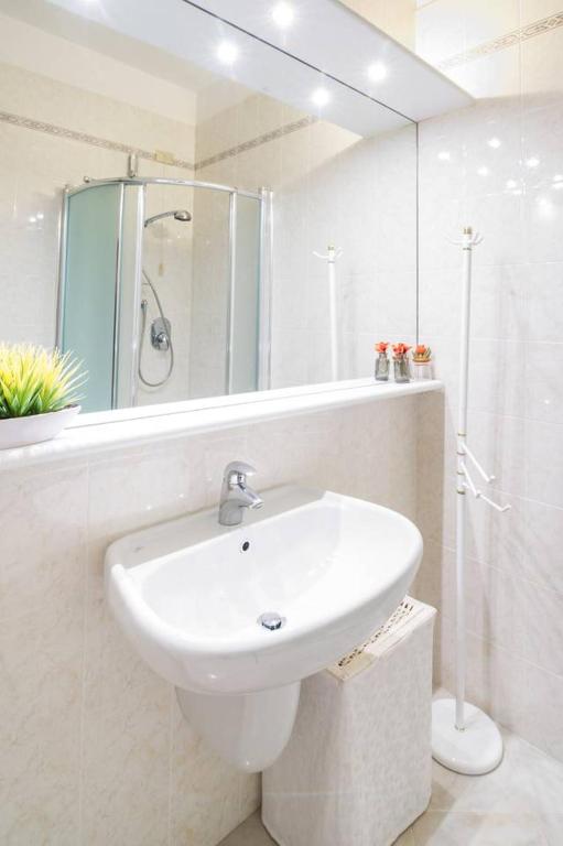 biała łazienka z umywalką i prysznicem w obiekcie Galilei61 - 3 camere, 2 bagni, garage e vista mare w San Remo