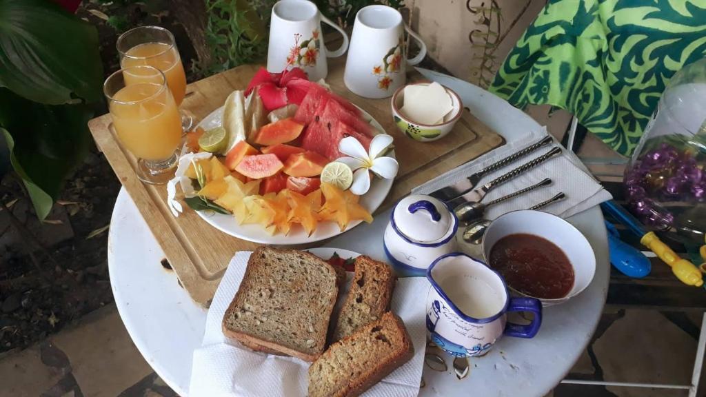 einen weißen Tisch mit Teller mit Lebensmitteln und Obst in der Unterkunft AU FARE MOENAU in Paea