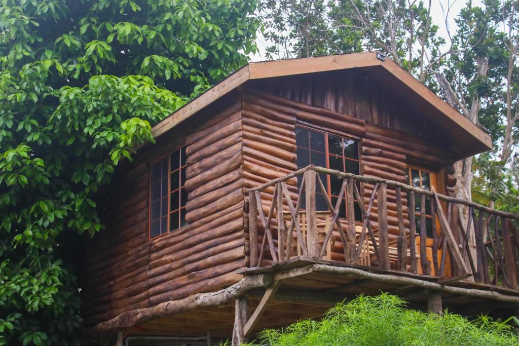 a log cabin in the woods with a balcony at Log 33 in Ocho Rios