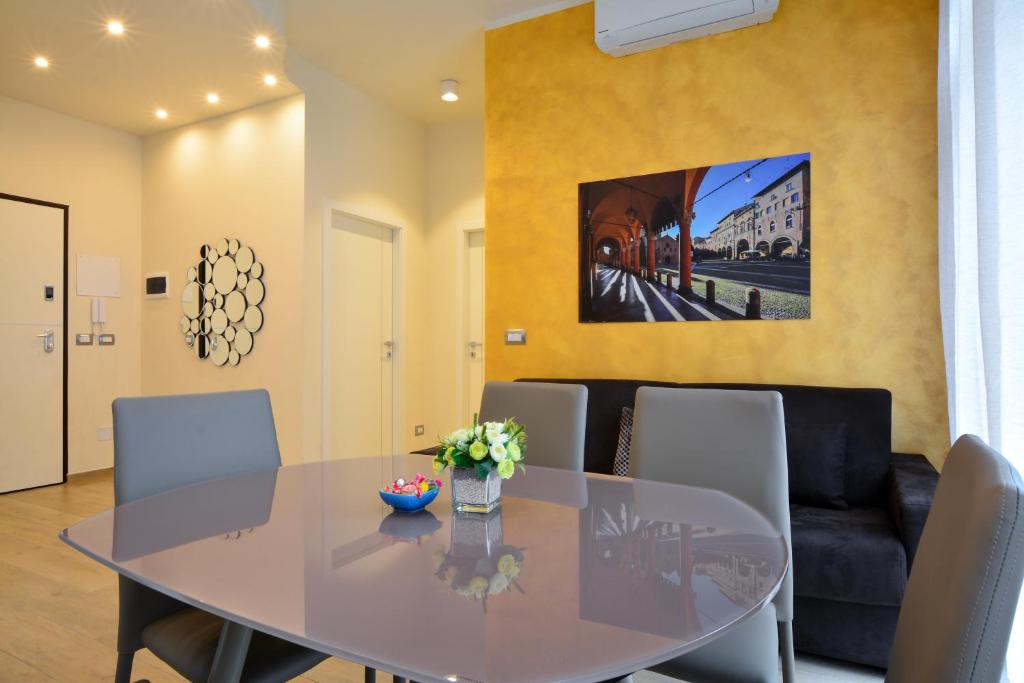 a dining room with a glass table and chairs at La Dotta Apartments in Bologna