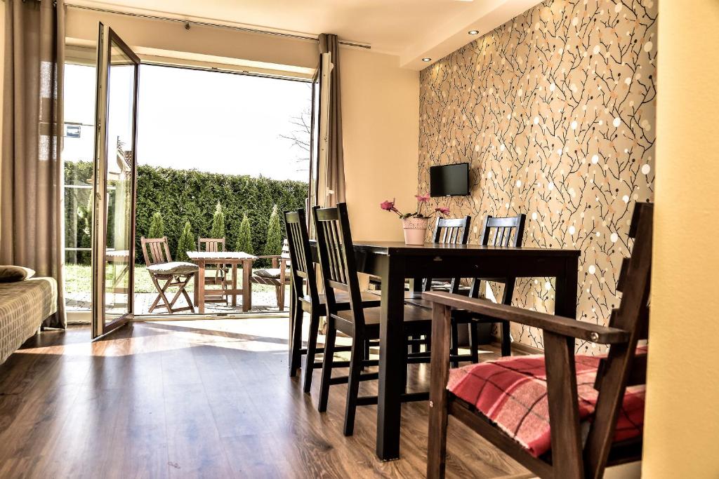 a dining room with a table and chairs and a balcony at Apartament Południowy in Debina