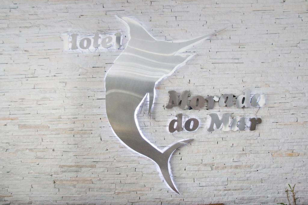 uma parede branca com um sinal que diz "idiota faz-me" em Hotel Morada do Mar no Guarujá