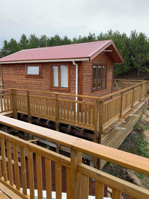 a wooden cabin with a wooden deck at Cosy cottage-Golden circle in Kerhraun