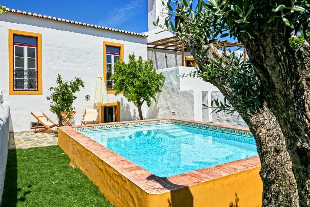 a swimming pool in a yard next to a house at Casa de Veiros - Estremoz in Estremoz