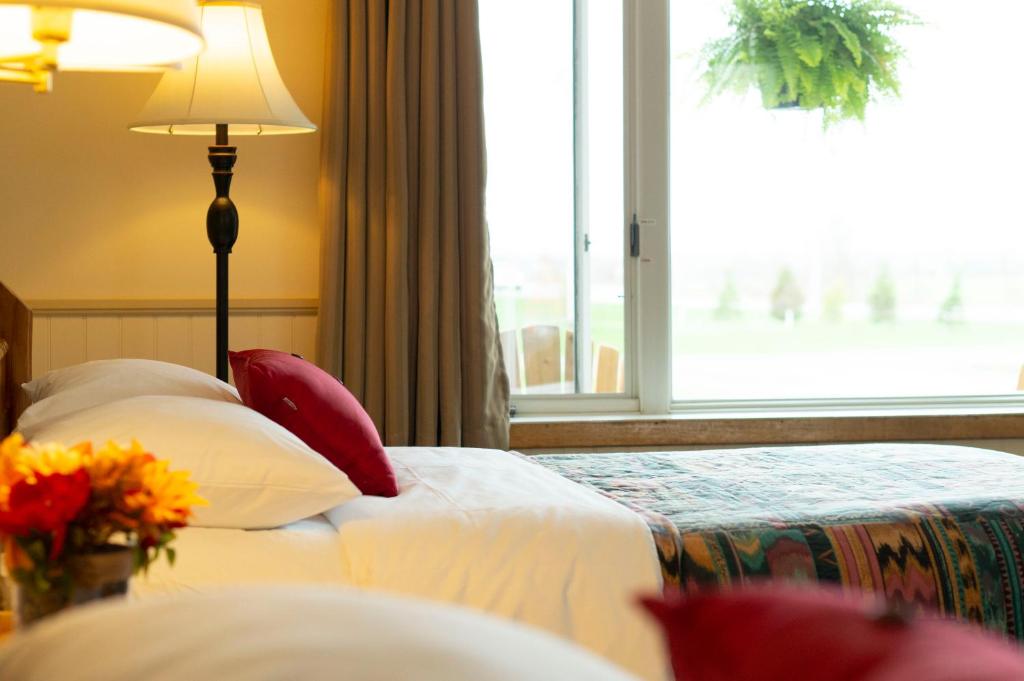 a hotel room with two beds and a window at Wayside Motel Manitoulin in Manitowaning