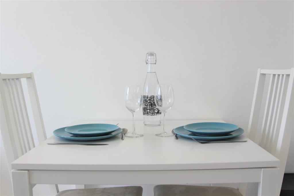 a white table with two plates and wine glasses at Clos Chantegrive in Saint-Médard-en-Jalles