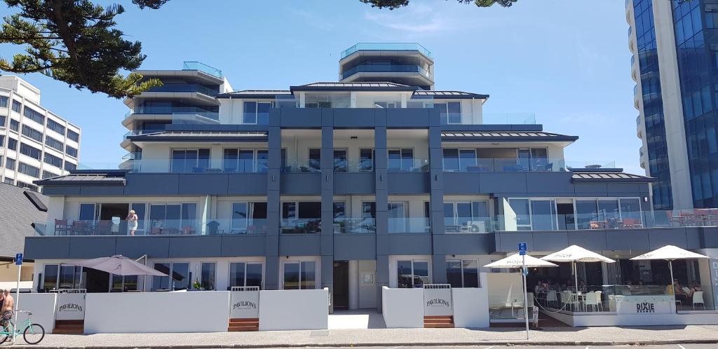 a building with umbrellas in front of it at Pavilion Beachfront Apartments in Mount Maunganui