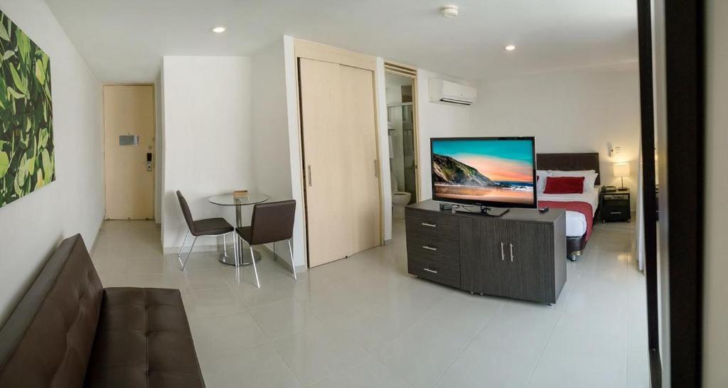 Bonito apartamento en la ciudad bonita في بوكارامانغا: غرفة معيشة مع أريكة وتلفزيون على خزانة