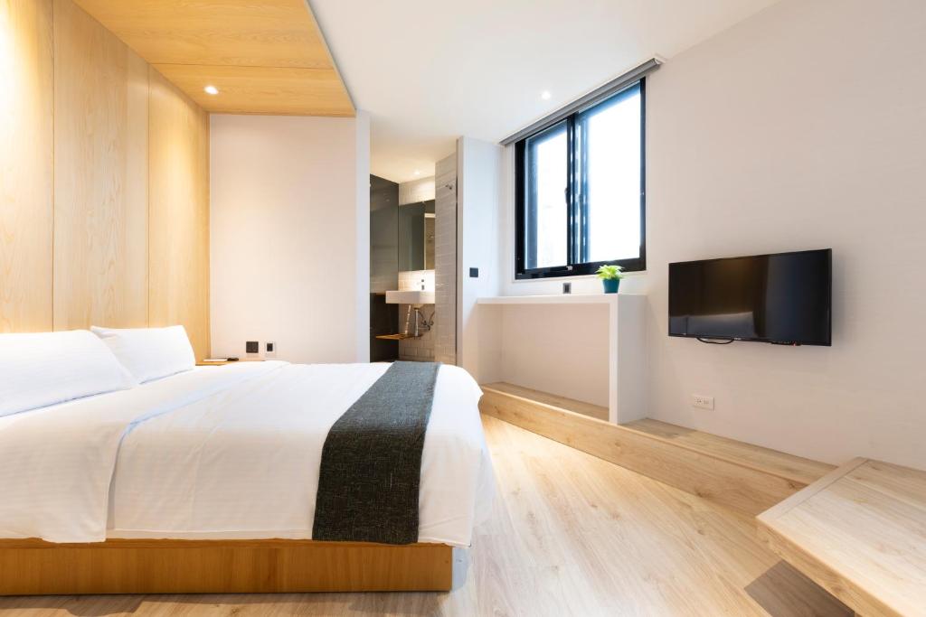 a bedroom with a bed and a flat screen tv at Meander Taipei Hostel - Ximending in Taipei