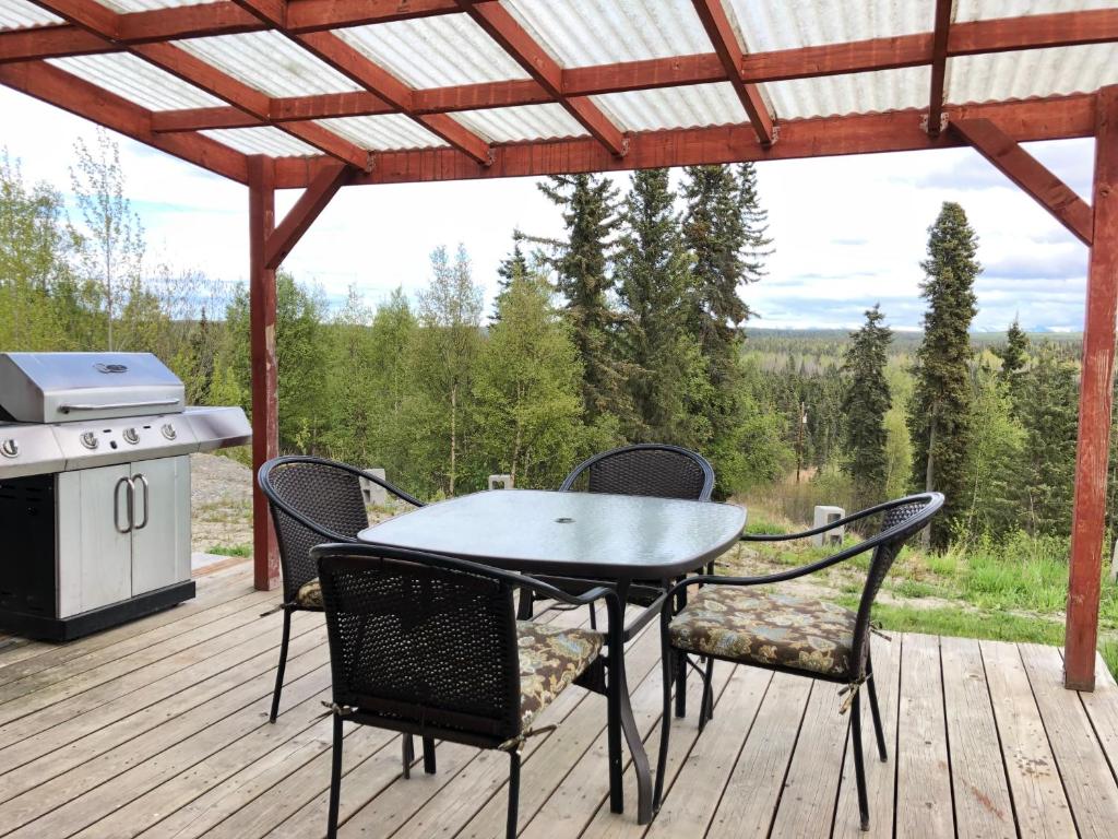 a table and chairs on a deck with a grill at Alaska Home Rental in Soldotna