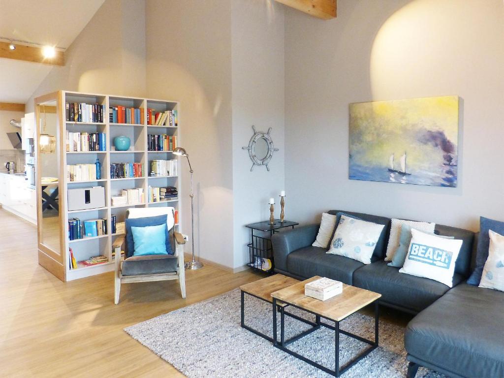 a living room with a couch and a book shelf at Weiße Düne Ferienwohnung *Weiße Düne 7* in Wittdün